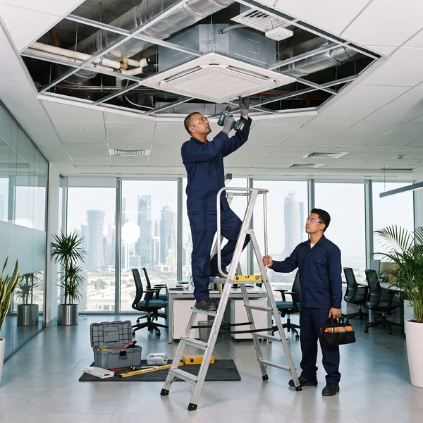 Ceiling cassette air conditioner being installed in an office